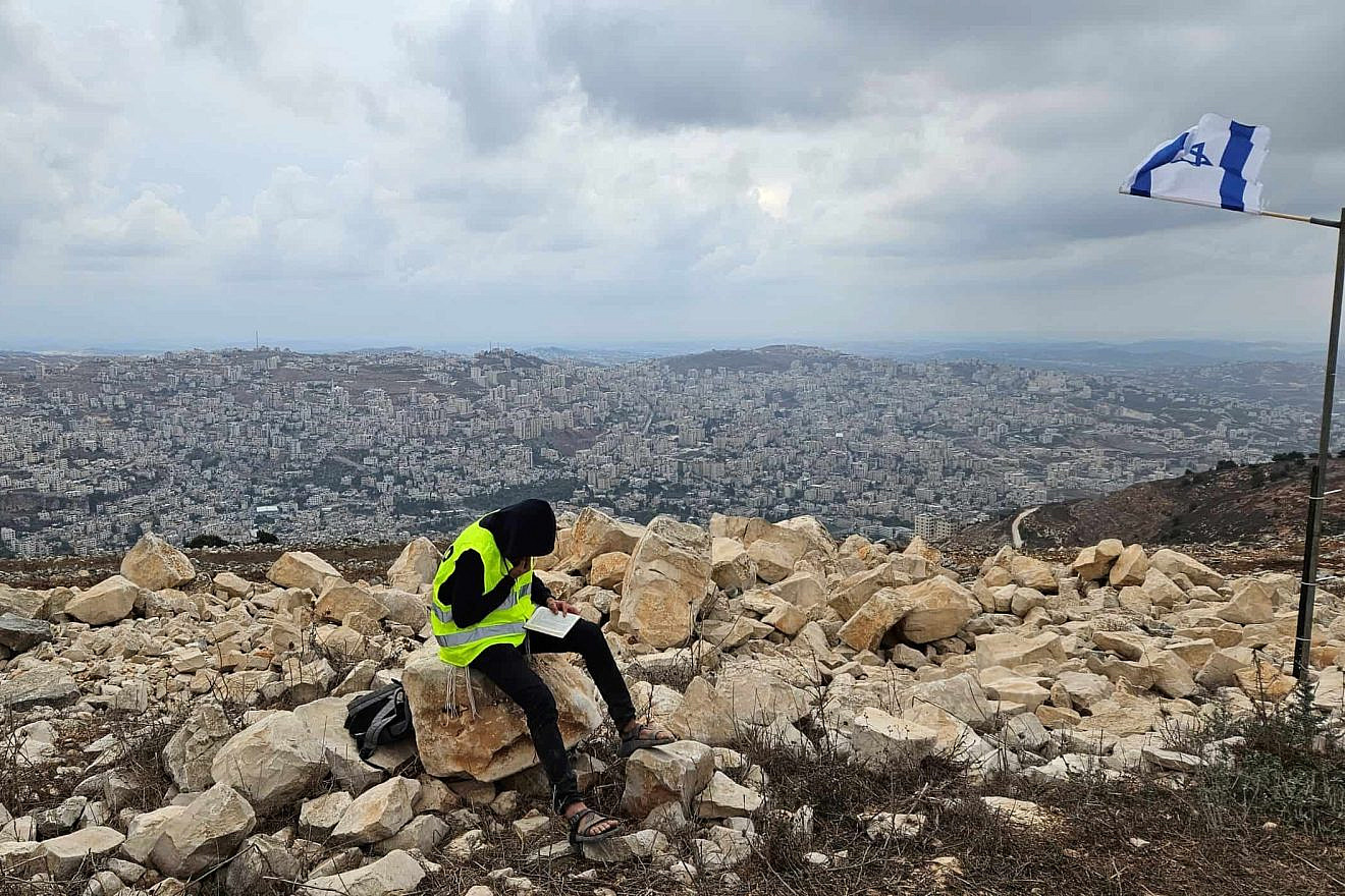 A yeshiva student learning Talmud overlooking Nablus during a tour at Joshua's Altar on Mt. Ebal in Samaria. Photo: Benjamin Sipzner.