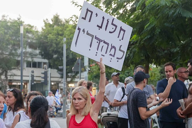 A secular protester holds a sign reading "strictly secular" at a demonstration against a gender-segregated Yom Kippur prayer service at Dizengoff Square in Tel Aviv on Yom Kippur, Sept. 25, 2023. Credit: Itai Ron/Flash90.