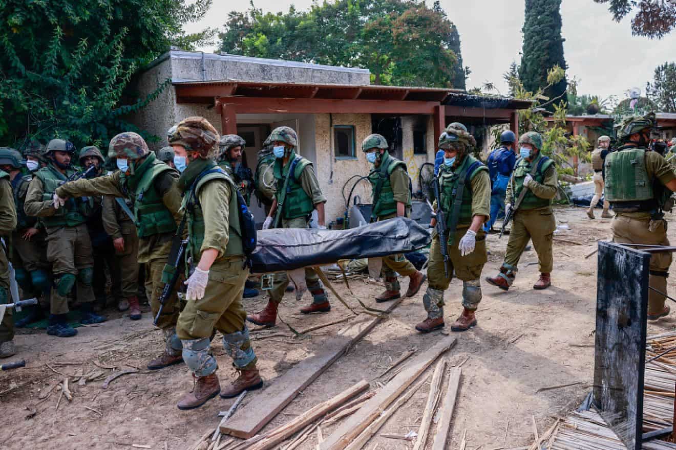 Israeli soldiers remove bodies of civilians in Kibbutz Kfar Aza, Oct. 10, 2023. Photo by Chaim Goldberg/Flash90.