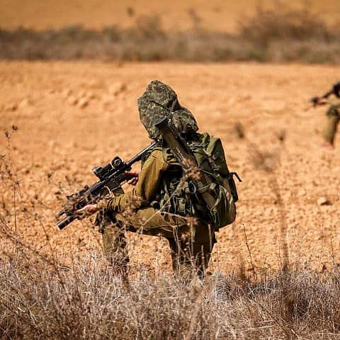Israeli soldiers take position on a main road near the Israeli-Gaza border, Oct. 10, 2023. Photo by Chaim Goldberg/Flash90.