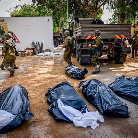 IDF soldiers remove the corpses of civilians in Kibbutz Kfar Aza, near the Gaza Strip, Oct. 10, 2023. Photo by Chaim Goldberg/Flash90.