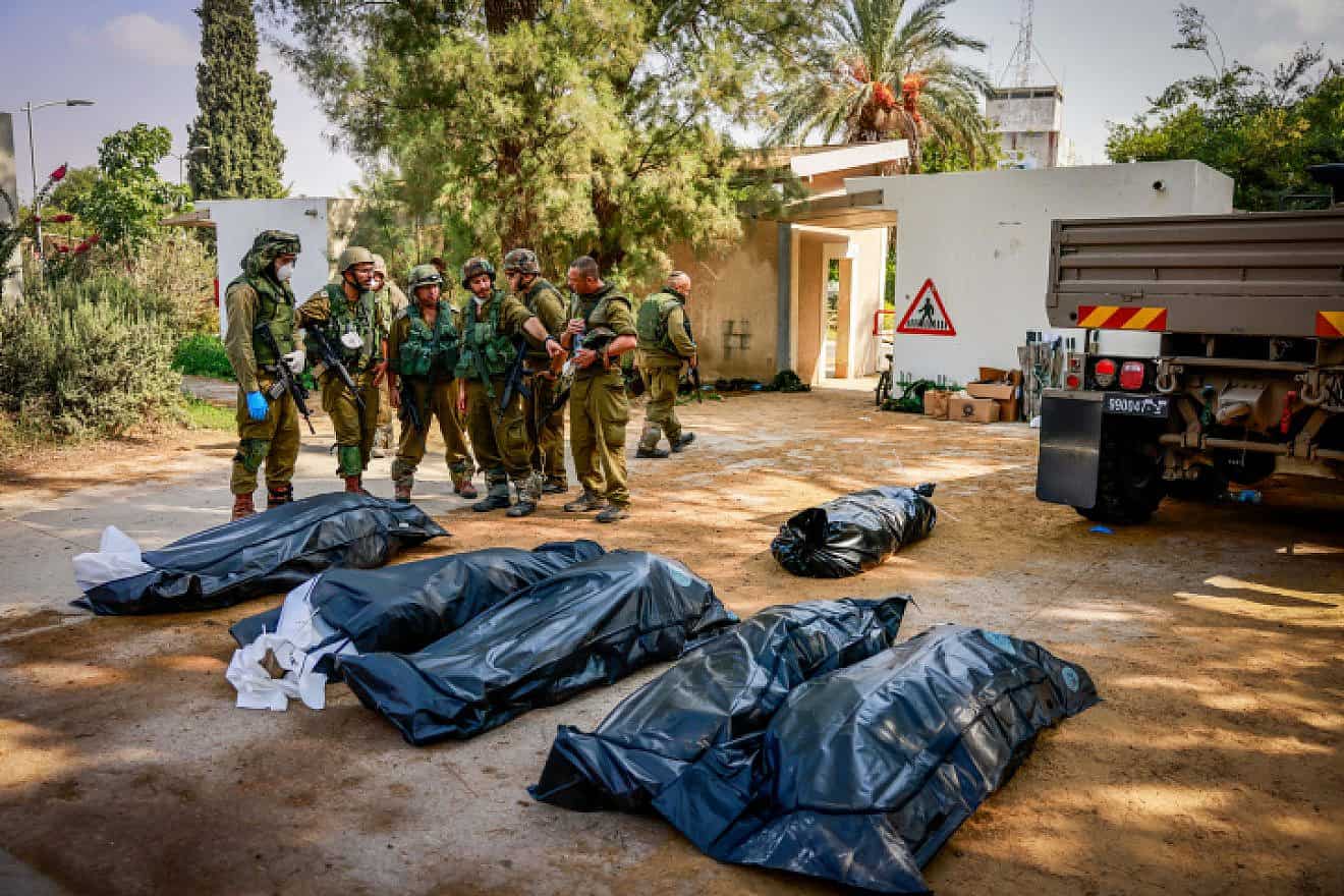 Israeli soldiers remove corpses in Kibbutz Kfar Aza, near the Gaza border, Oct. 10, 2023. Photo by Chaim Goldberg/Flash90.