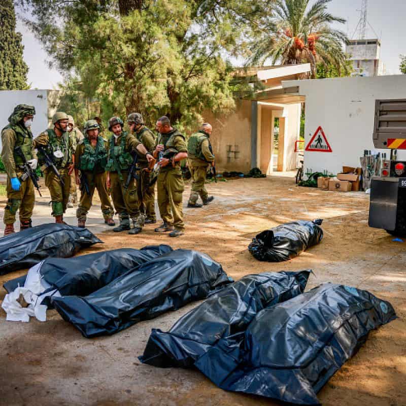Israeli soldiers remove corpses in Kibbutz Kfar Aza, near the Gaza border, Oct. 10, 2023. Photo by Chaim Goldberg/Flash90.