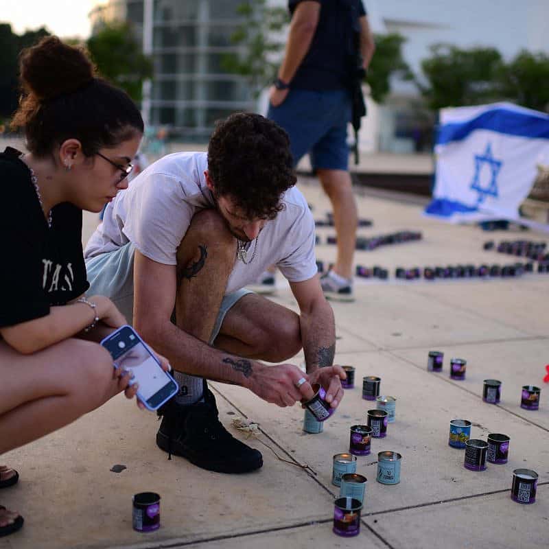 Musicians from the Israeli Philharmonic Orchestra seen performing next to lit candles in an event at haBima square in memory of the more than 1300  killed by Hamas terrorists, and more than 200 held hostage in Gaza.   October 22, 2023. Photo by Tomer Neuberg/Flash90 *** Local Caption *** מלחמה
חטופים
משפחות
תל אביב
אירוע מדליקים את האור של הפילהרמונית
