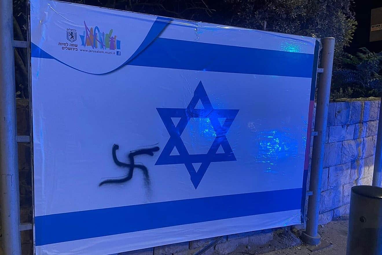 An Israeli flag in Jerusalem spray-painted with a swastika. Credit: Israel Police.