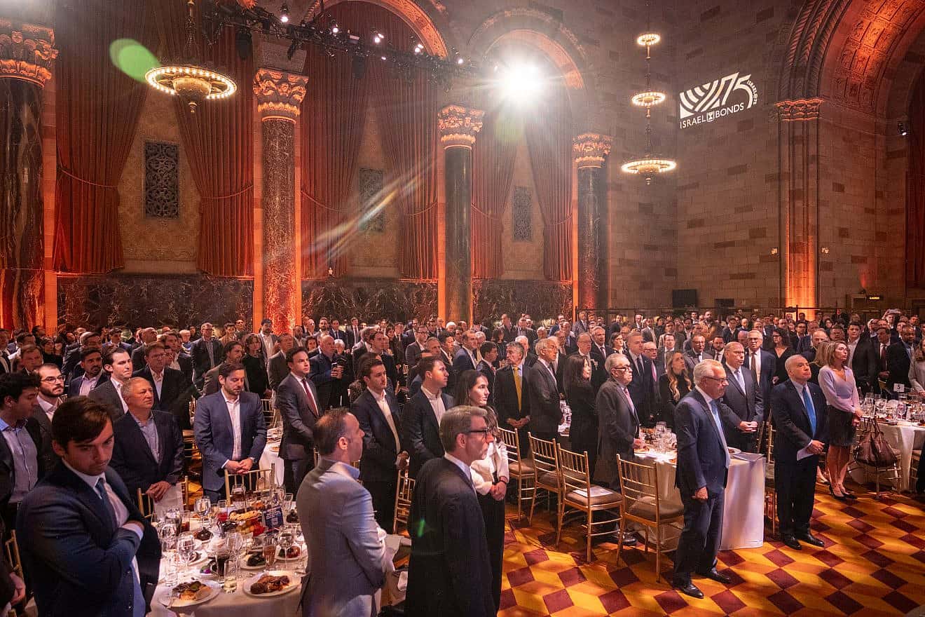 Israel Bonds Real Estate & Allied Division Luncheon guests stand in a moment of silence for the victims of the terrorist attacks by Hamas on Oct. 7 in Israel. Photo by Shahar Azran.