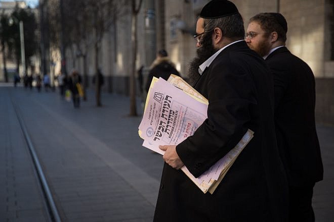Representatives of the Chief Rabbinate of Israel cross Jaffa Road as they deliver a kashrut certificate to a restaurant in Jerusalem, Dec. 31, 2019. Photo by Hadas Parush/Flash90.