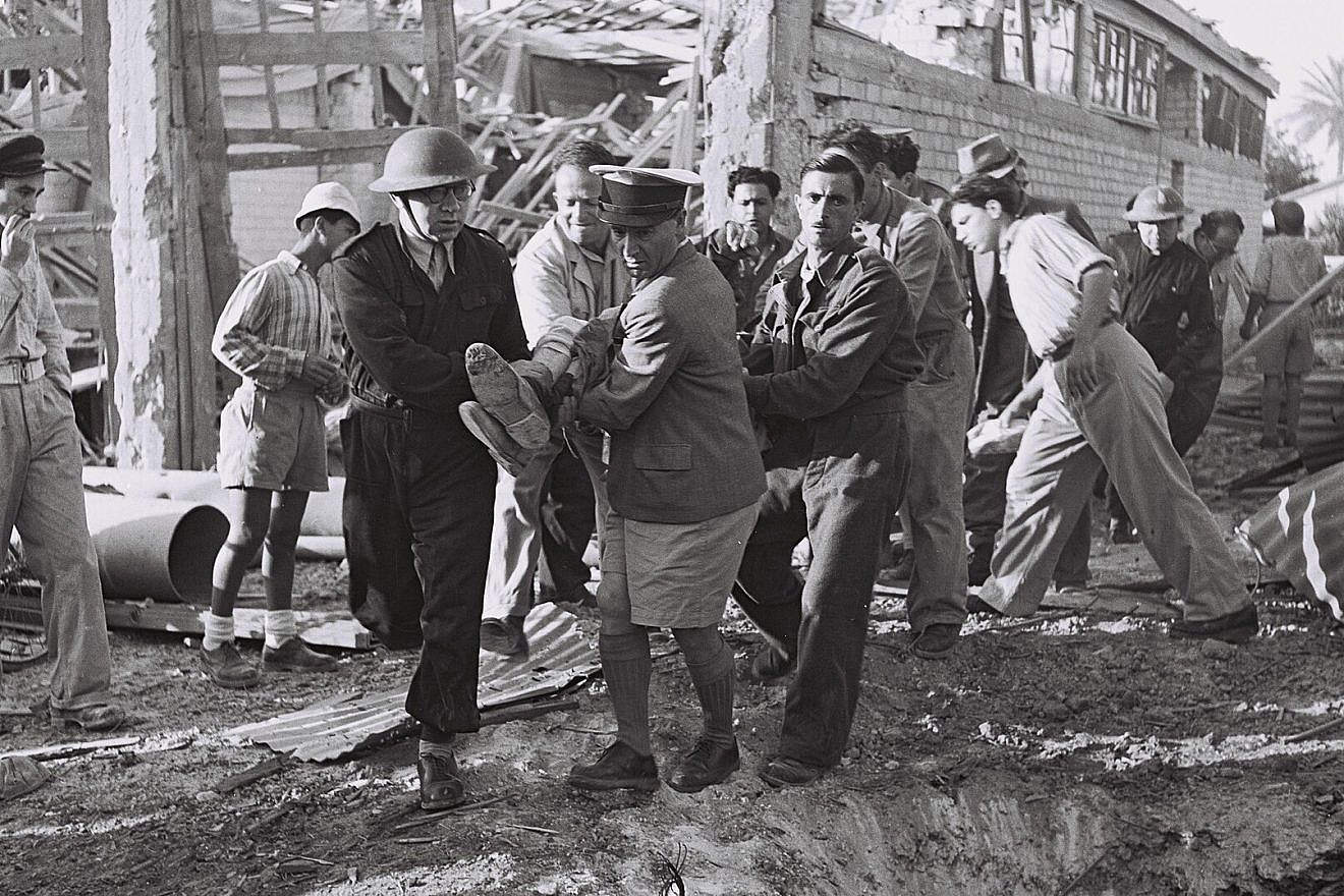 Haganah volunteers evacuate a man wounded in an Egyptian aerial bombardment of Tel Aviv during the War of Independence, May 15, 1948. Photo by Frank Scherschel/GPO via Wikimedia Commons.