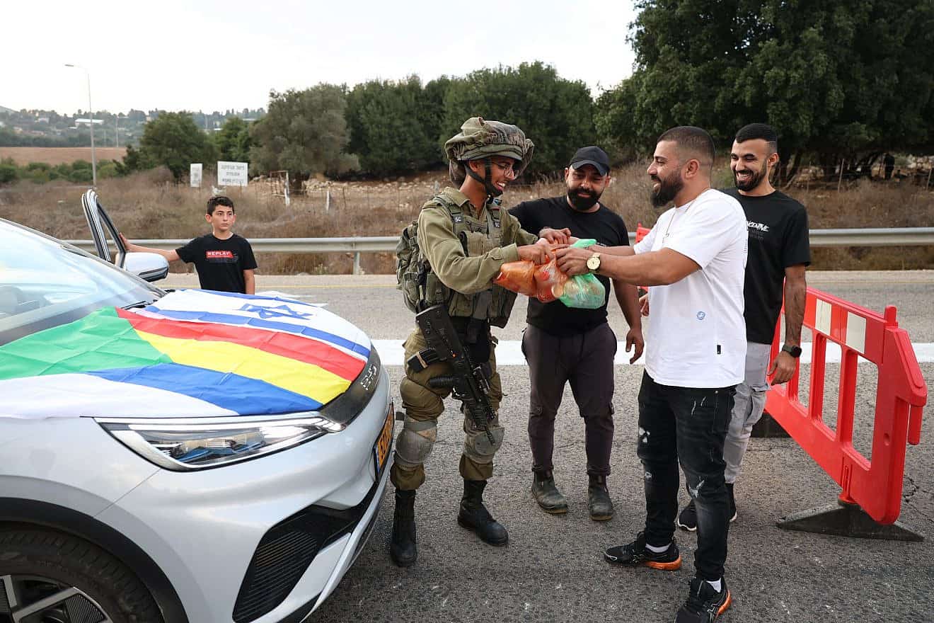 Druze Israelis hand out food to soldiers standing guard on a road near the border with Lebanon, Oct. 9, 2023. Photo by David Cohen/Flash90.