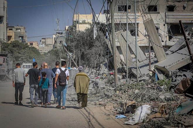 Palestinians walk near the rubble of a destroyed building Khan Yunis, in the southern Gaza Strip, on Oct. 30, 2023.  Photo by Atia Mohammed/Flash90.
