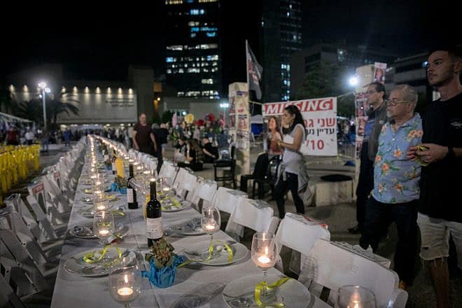A Shabbat table with 240 empty seats, representing the 240 civilians held hostage by Hamas terrorists in Gaza, at the "Hostages' Square" outside Israeli Defense Ministry headquarters in Tel Aviv, Nov. 13, 2023. Photo by Miriam Alster/Flash90.