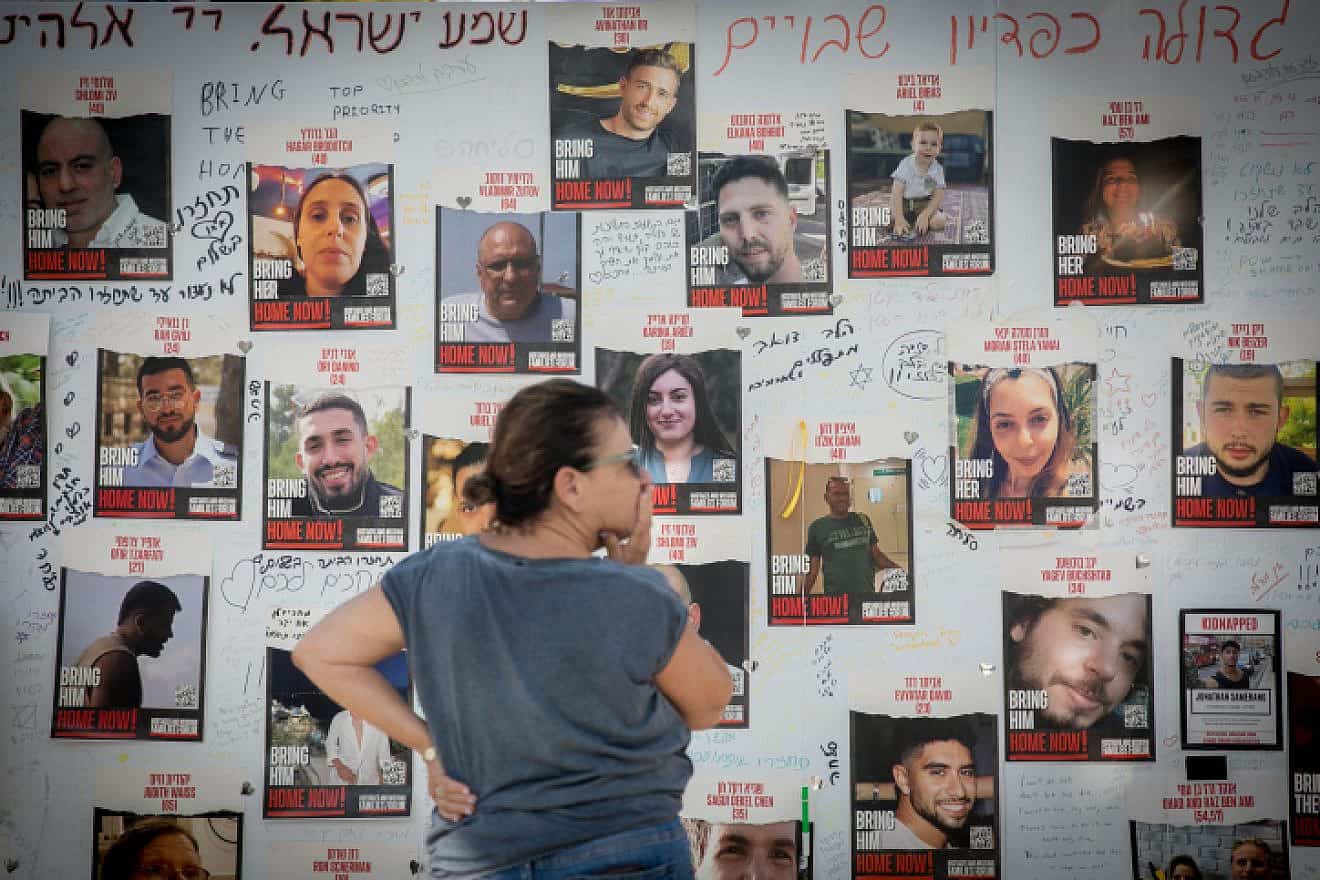 A woman looks at photographs of Israelis held by Hamas in Gaza, at "Hostage Square" outside the Tel Aviv Museum of Art, Oct. 30, 2023. Photo by Miriam Alster/Flash90.