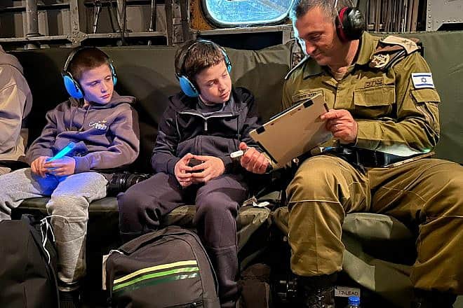 An Israeli soldier shares exchanges in an Israeli Air Force helicopter with Tal, 9, and Gal Goldstein, 11, of Kfar Aza (their mother, Chen Goldstein, 48, and sister, Agam Goldstein, 17, were also released), on their return to Israel from Hamas captivity in the Gaza Strip, Nov. 26, 2023. Credit: Courtesy of the IDF Spokesperson.