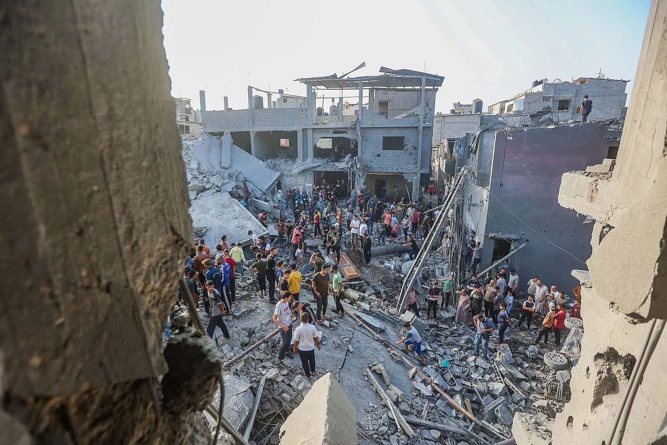 Palestinians at the rubble of a destroyed building after an Israeli airstrike in the central Gaza Strip on Nov. 5, 2023. Photo by Atia Mohammed/Flash90.