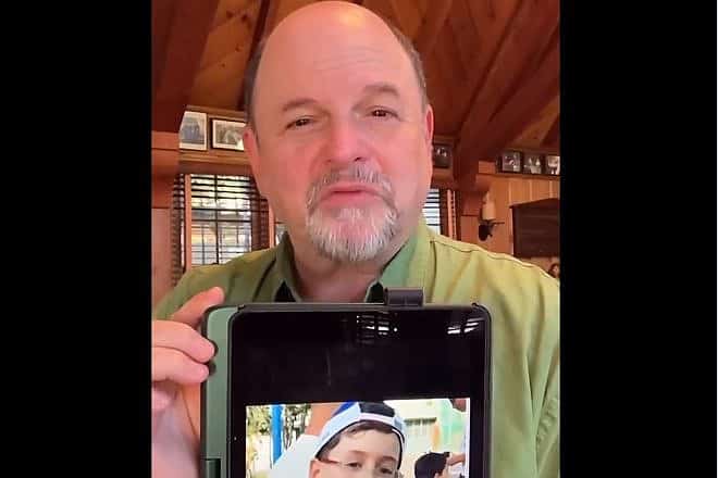 Actor Jason Alexander holds a picture of 9-year-old Ohad Munder-Zichri, Nov. 18, 2023. Source: X.