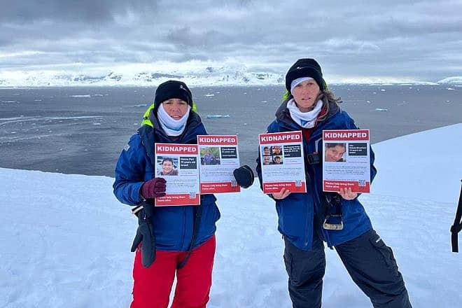 Israeli researchers Dr. Tal Luzzatto Knaan and Prof. Tali Mass hold photos in Antarctica of Israelis held in Gaza. Credit: University of Haifa.