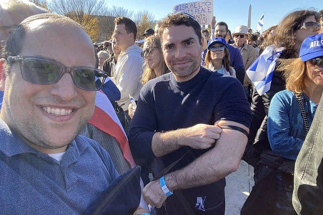 The comedian Eli Lebowicz (left) helped fellow participants at the "March for Israel" wrap tefillin on Nov. 14, 2023. Credit: EliComedy.com.