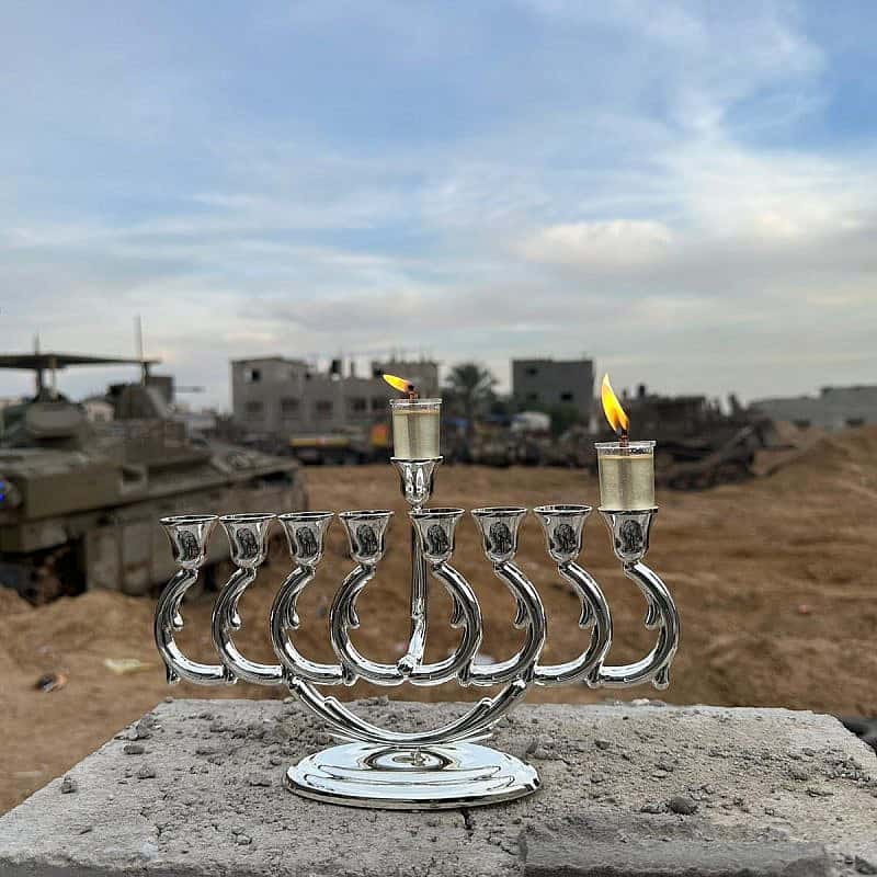 Israeli troops operating in the Gaza Strip light a menorah on the first day of the Chanukah holiday, Dec. 8, 2023. Credit: IDF.