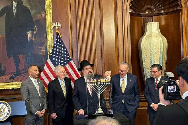 Rabbi Levi Shemtov lights the U.S. Capitol Menorah as (from left) House Minority Leader Hakeem Jeffries (D-N.Y.), Senate Minority Leader Mitch McConnell (R-Ky.), Senate Majority Leader Charles Schumer (D-N.Y.) and House Speaker Mike Johnson (R-La.) look on. Credit: Chabad.org/News.