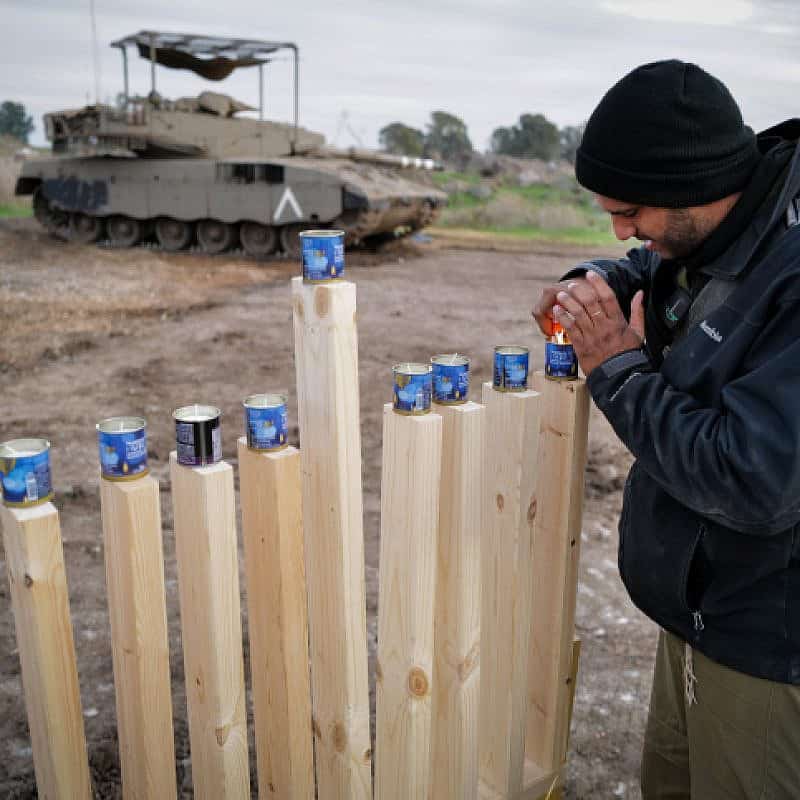 Israeli soldiers light candles on the second night of Chanukah, at a staging area near the Israeli border with Syria, on Dec. 8, 2023. Photo by Michael Giladi/Flash90.