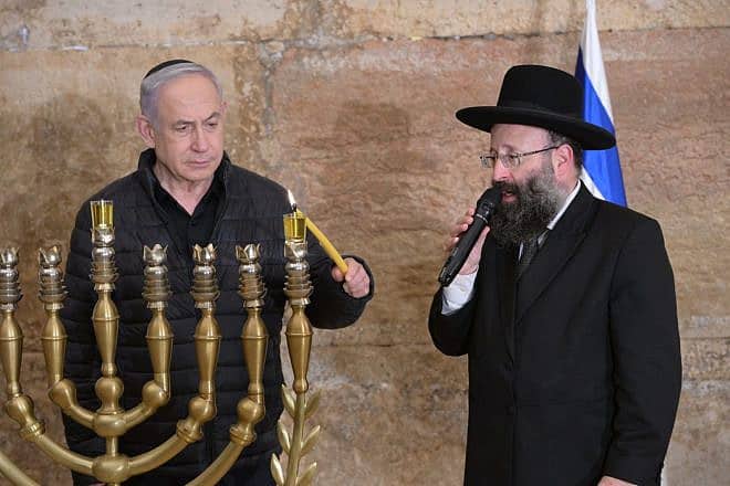 Israeli Prime Minister Benjamin Netanyahu lights the first Chanukah candle at the Western Wall in Jerusalem, Dec. 7, 2023. Photo by Amos Ben-Gershom/GPO.