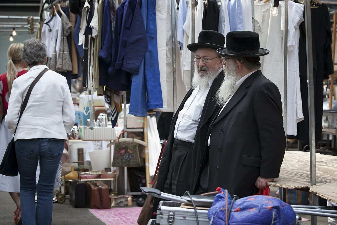 Orthodox Jewish men chat at Spitalfields market in the Stamford Hill neighborhood of London, Aug. 27, 2016. Credit: Elena Rostunova/Shutterstock.