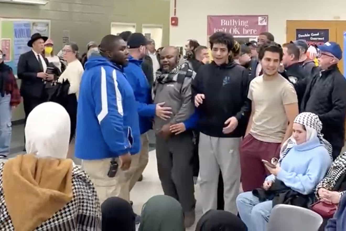 Rick Whilby (center in gray shirt, with scarf) after delivering an antisemitic rant at a Teaneck education board meeting on Dec. 13, 2023. Source: Screenshot.