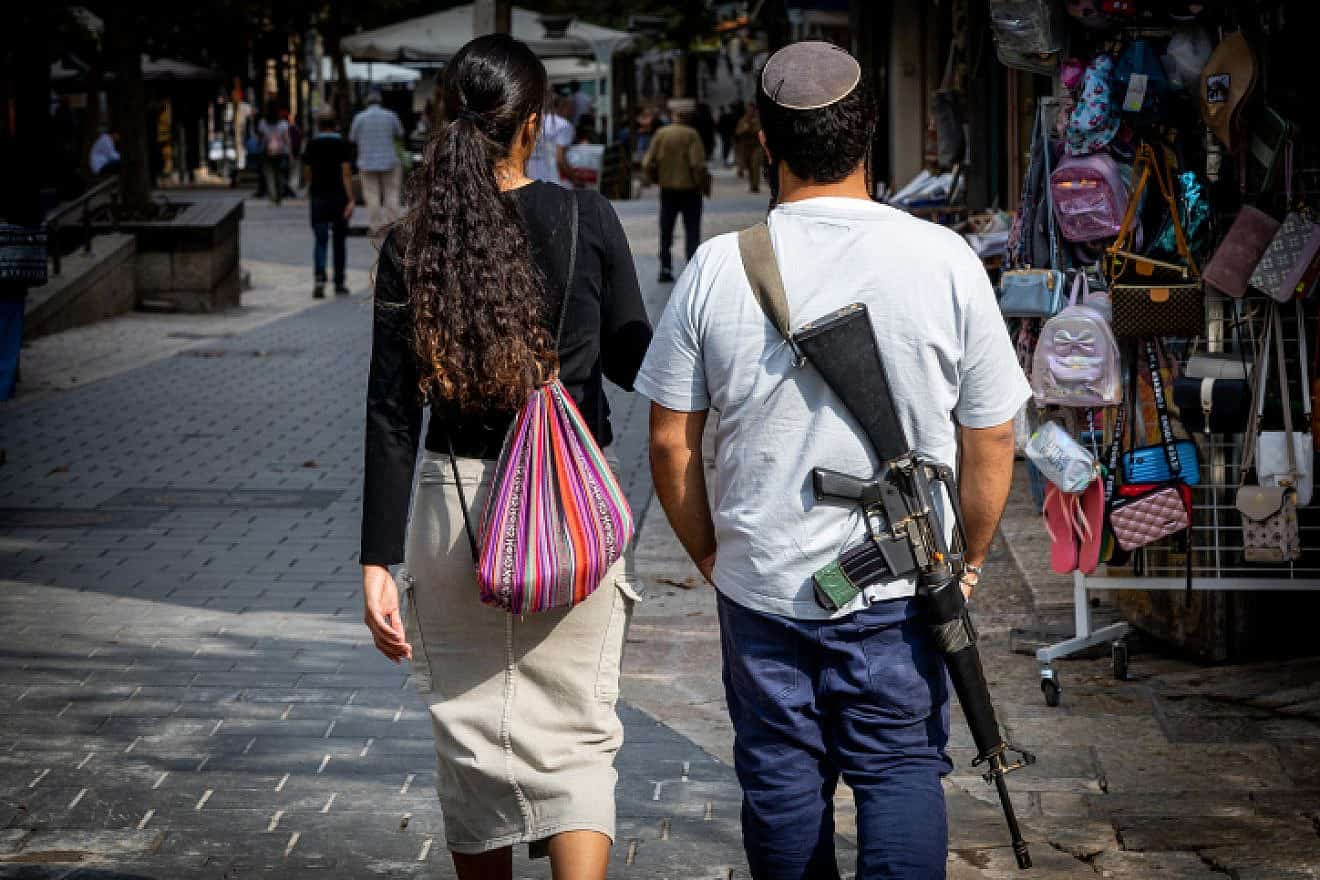 An Israeli carries an M16 assault rifle in downtown Jerusalem, Nov. 5, 2023. Photo by Nati Shohat/Flash90.