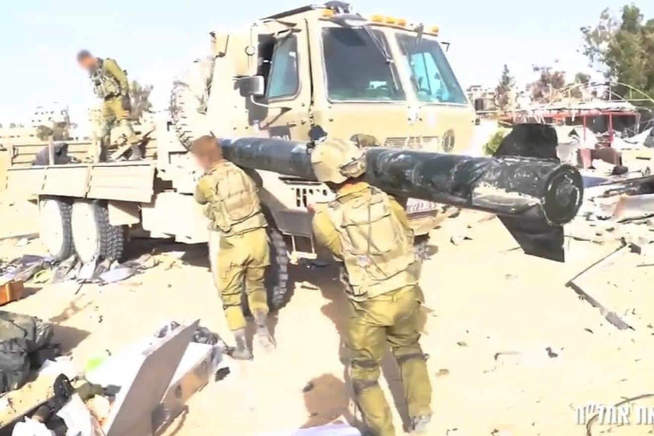 IDF troops confiscating one of the missiles found among hundreds of other weapons in a large stockpile in Gaza, Dec. 6, 2023. Screenshot: IDF/YouTube.