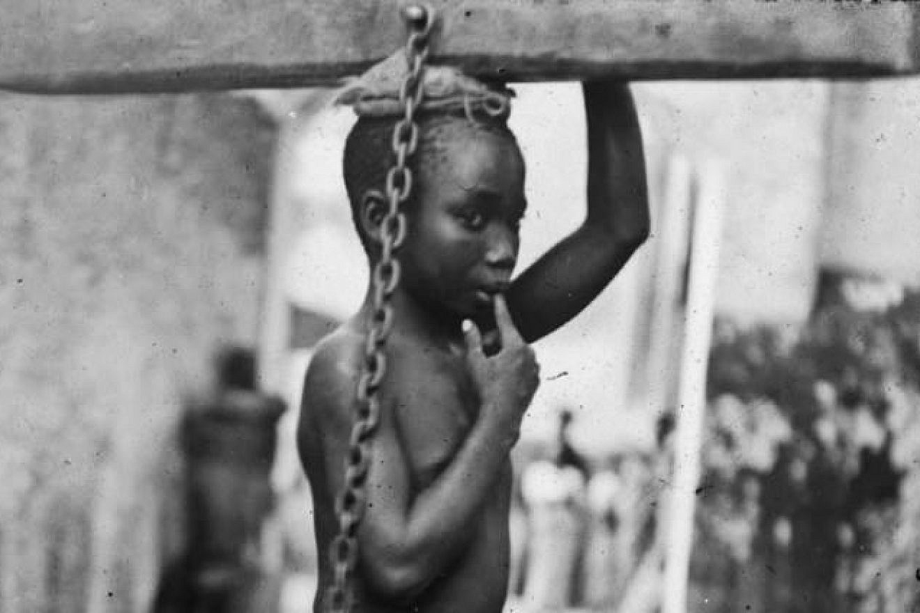 A photograph of an enslaved boy in Zanzibar, circa 1890. The original image states: "An Arab master's punishment for a slight offense." Source: public domain/Wikimedia