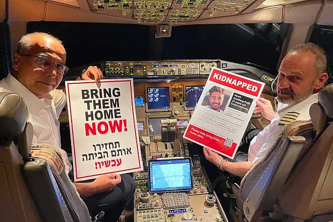 Pilots hold posters of Hamas captive Hersh Goldberg-Polin on the flight he would have taken on a planned trip to Southeast Asia. Photo: Courtesy of Matt Krieger.