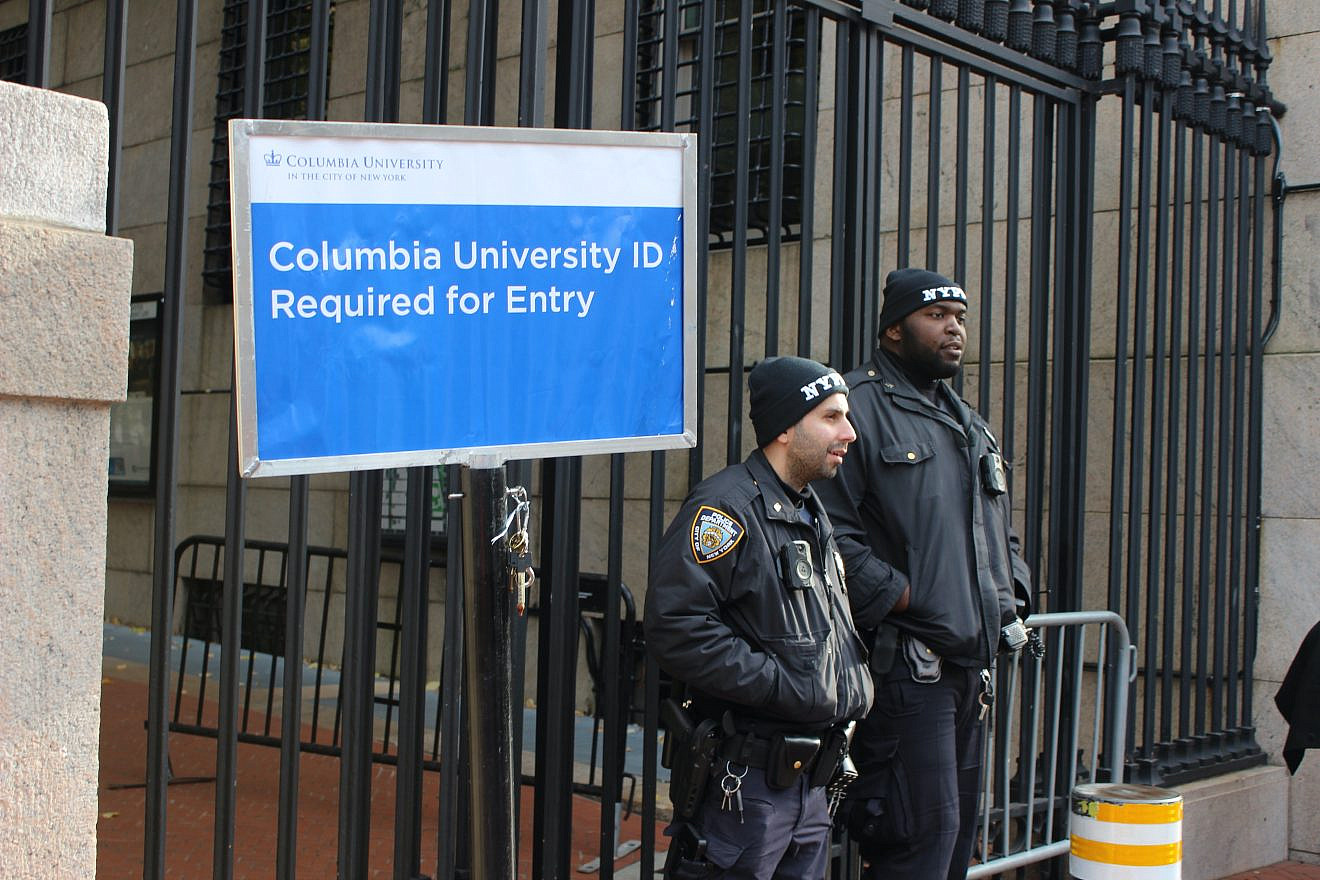 NYPD officers next to sign requiring ID in front of Columbia University's main gate on Nov. 15, 2023 during a protest after the suspension of anti-Israel student groups. Credit: Here Now/Shutterstock.