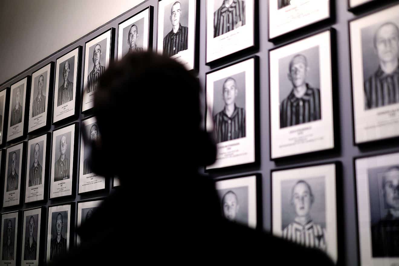 A visitor looks at the photographs of camp inmates in Auschwitz-Birkenau Museum and Memorial in Oswiecim, Poland. Credit: Shutterstock/Desi H. Sitorus.