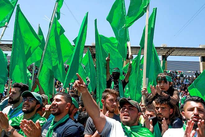 Hamas supporters wave the terror group's flag during a rally at Birzeit University, near Ramallah, on May 19, 2022. Credit: Flash90.