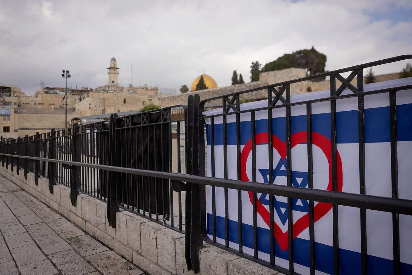 A heart painted on an Israeli flag in Jerusalem, Dec. 25, 2023. Photo by Chaim Goldberg/Flash90.