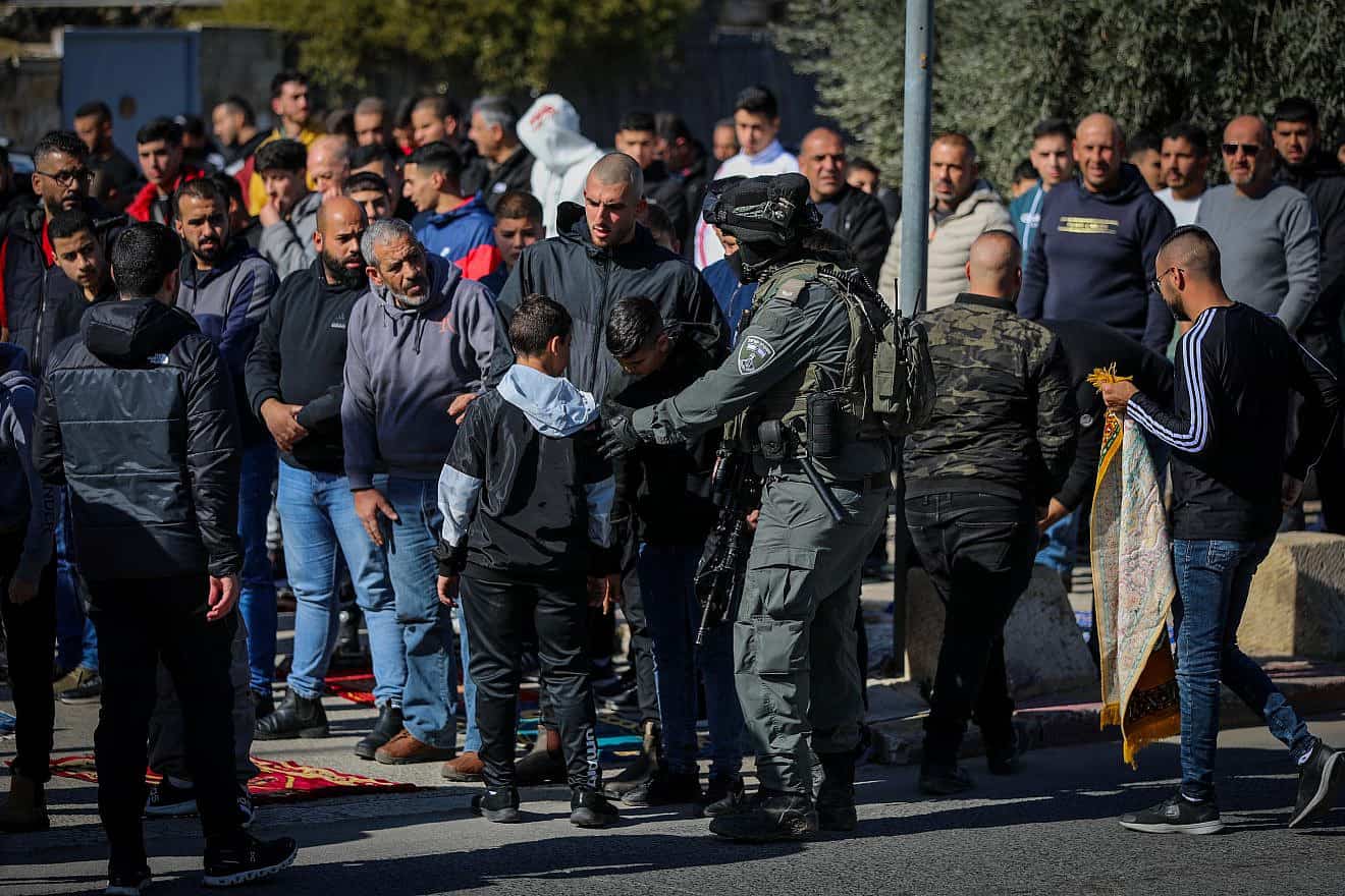 Israeli police guard while Palestinians perform Friday prayers in the eastern Jerusalem neighborhood of Ras Al Amud on Jan. 19, 2024. Photo by Jamal Awad/Flash90.