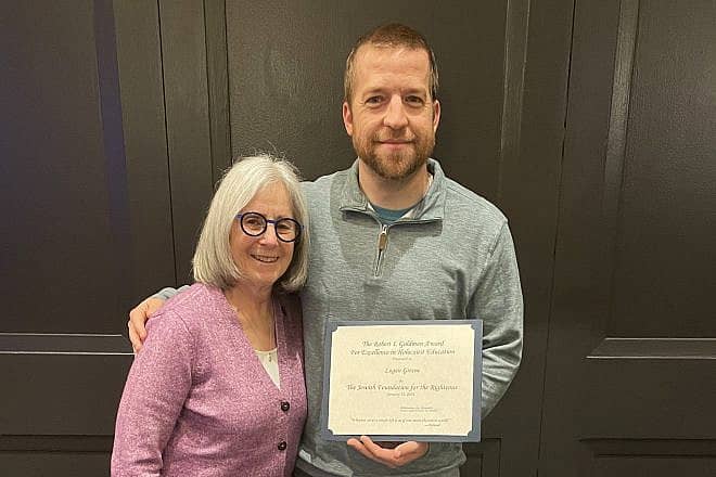Eighth-grade teacher Logan Greene receives the 2023 Robert I. Goldman Award for Excellence in Holocaust Education, presented by Stanlee Stahl, executive vice president of the Jewish Foundation for the Righteous, Jan. 15, 2024. Credit: Courtesy.