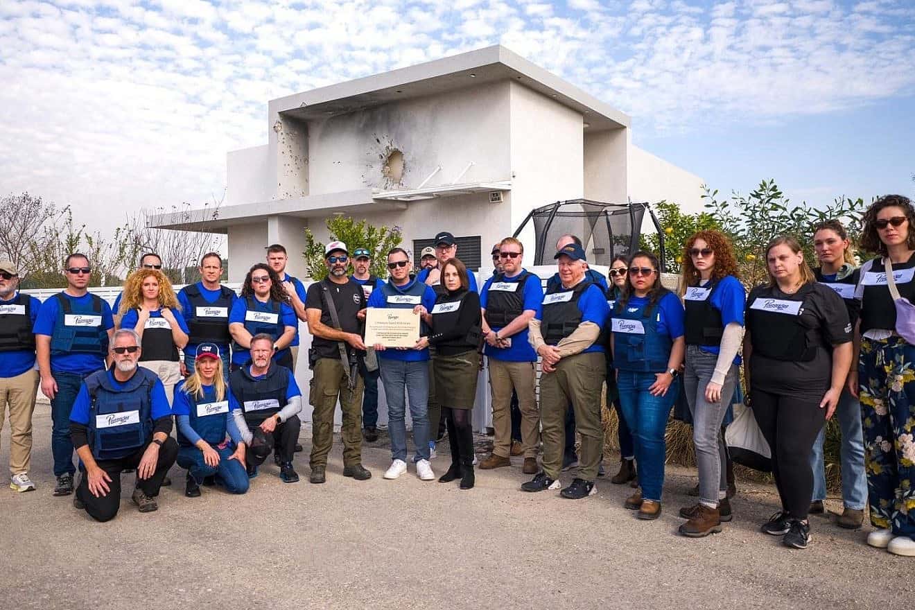 A Passages delegation presents a plaque to Benny Ledom, head of the security committee and a community leader of Netiv HaAsara in southern Israel on Jan. 25, 2023. Photo by Cade Chudy.