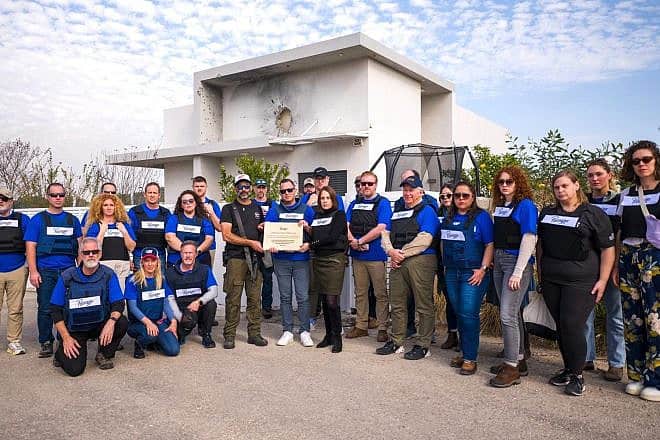 A Passages delegation presents a plaque to Benny Ledom, head of the security committee and a community leader of Netiv HaAsara in southern Israel on Jan. 25, 2023. Photo by Cade Chudy.