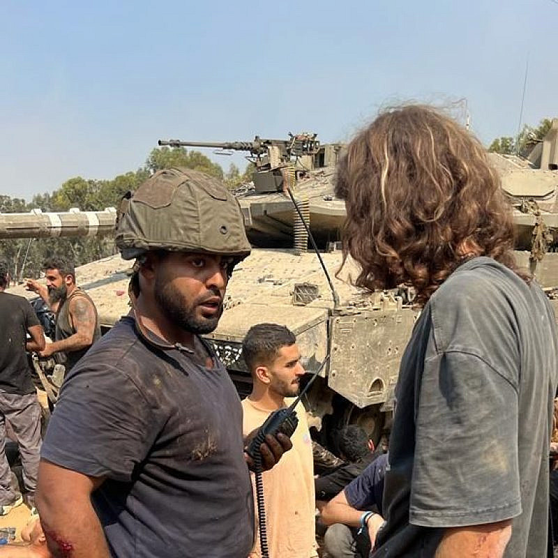 Daniel Sharabi (wearing helmet) and other Israelis regroup and treat the wounded after fleeing Hamas's attack on the Supernova Music Festival at Kibbutz Re'im on Oct. 7. Credit: Courtesy.