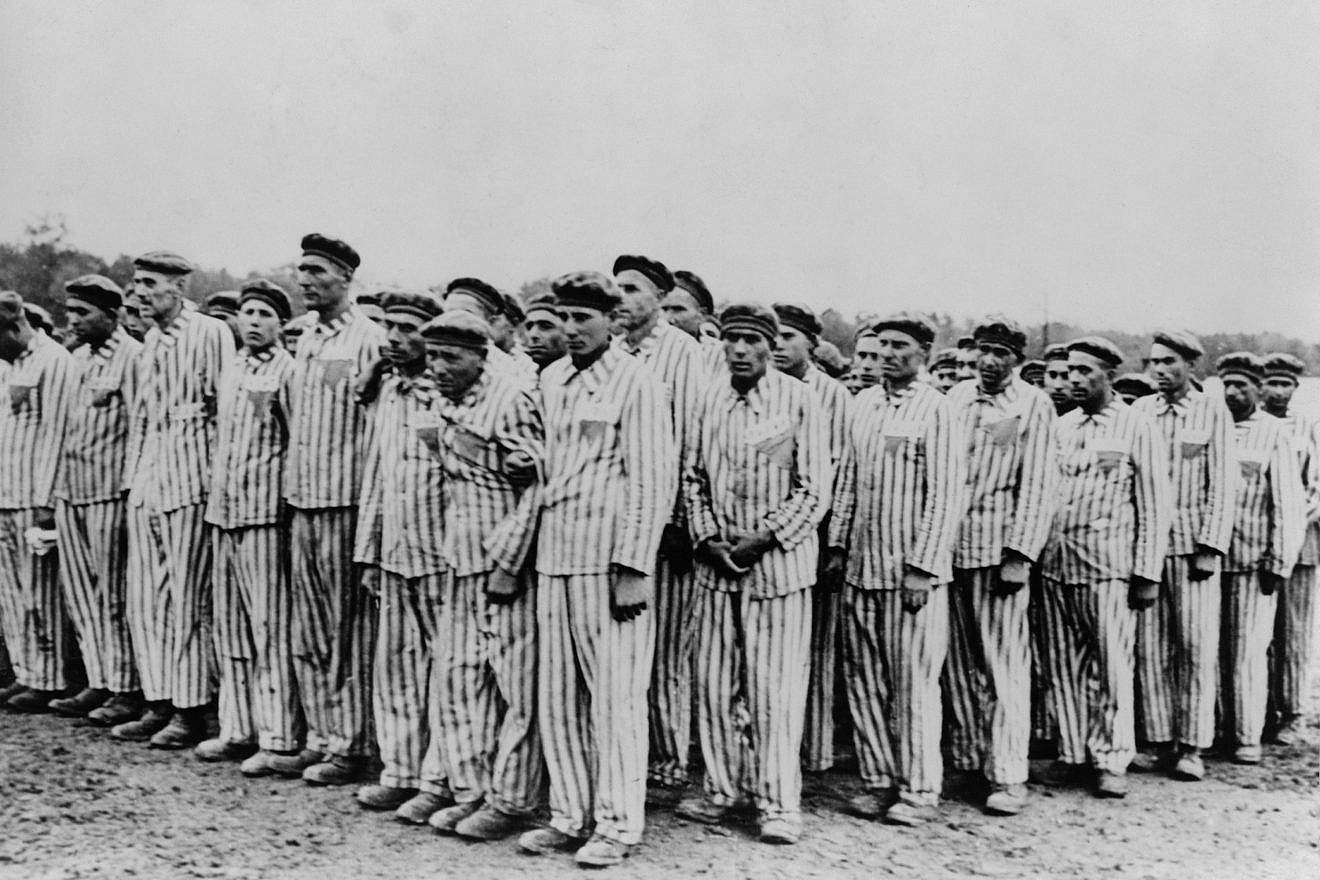Roll call at Buchenwald concentration camp, c. 1938-1941. Two prisoners in the foreground are seen supporting a comrade, as fainting was frequently an excuse for the guards to “liquidate” useless inmates. Credit: Everett Collection/Shutterstock.