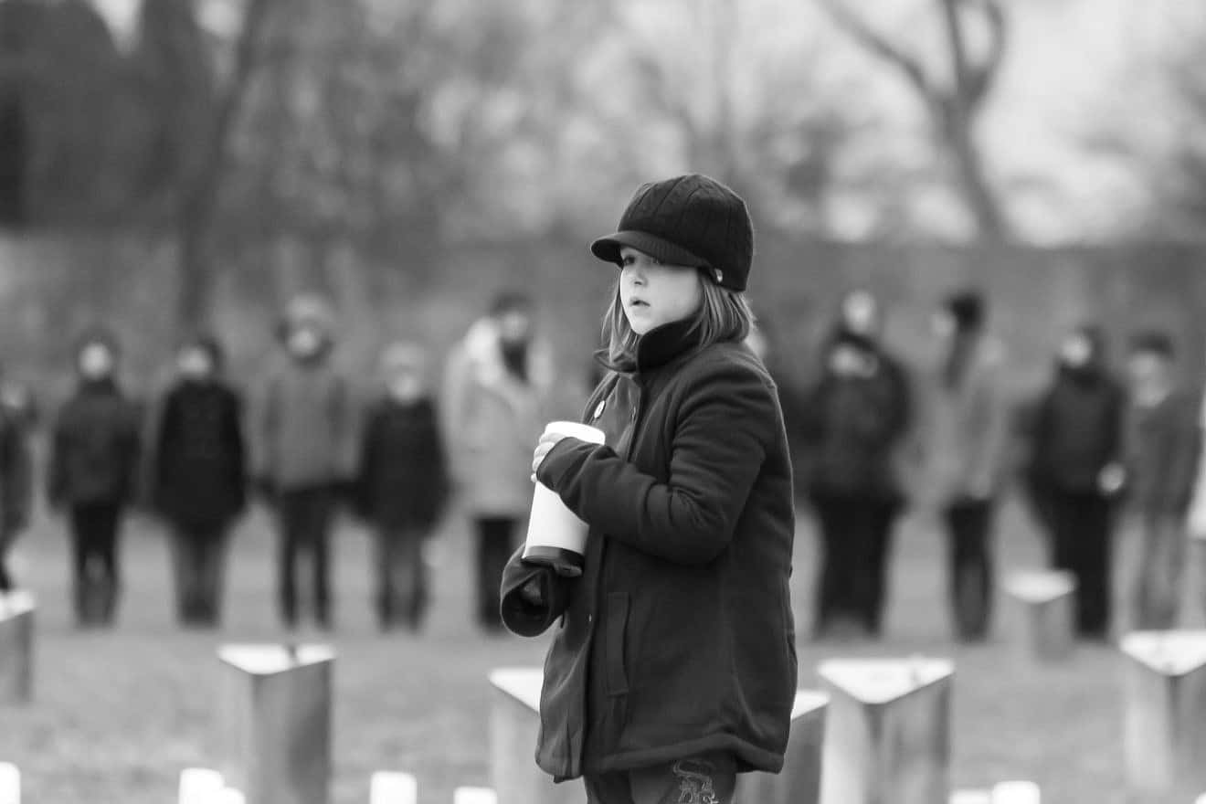 A young girl holds a candle at the Holocaust memorial ceremony in the Terezin museum in the Czech Republic on the International Holocaust Remembrance Day, Jan. 27, 2015. Credit: Roman Yanushevsky/Shutterstock.