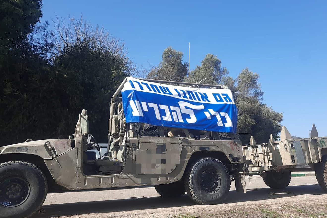 A protest banner hanging from the side of an IDF Hummer jeep. Credit: TPS.