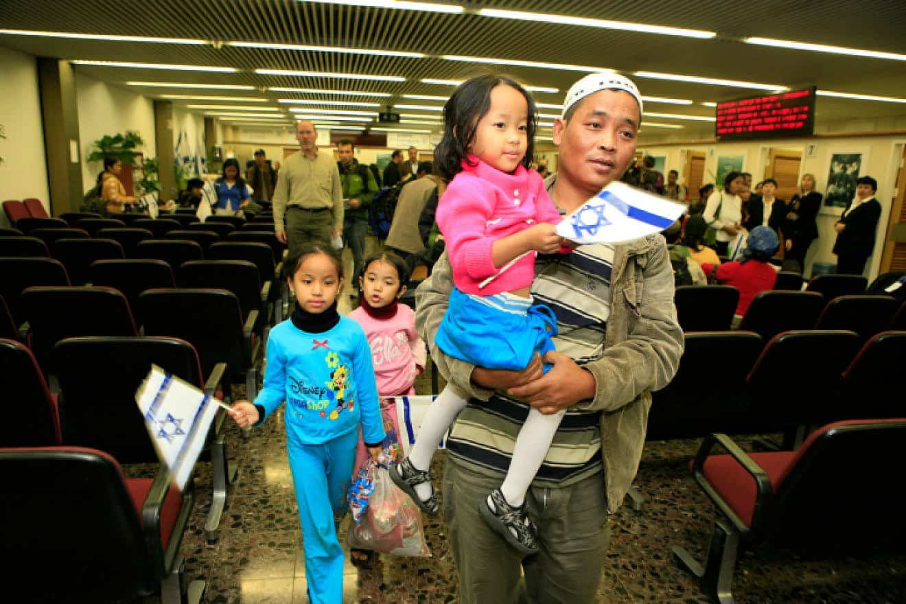Newly arrived immigrants from India, members of the Bnei Menashe community, hold Israeli flags as they arrive at Ben-Gurion Airport, Nov. 21, 2006. Photo by Nati Shohat/Flash90.