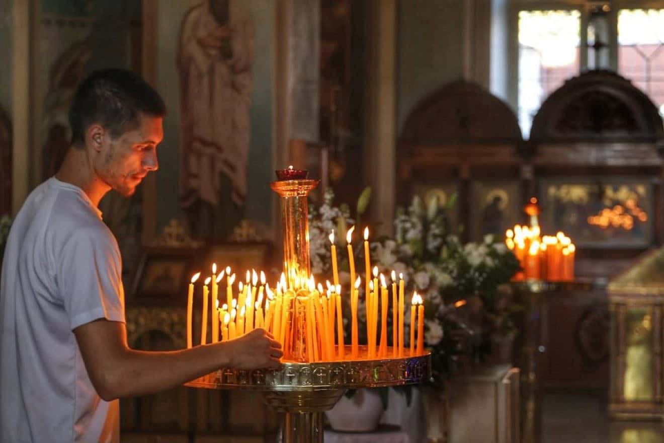 A man lights candles inside Jaffa's St. Peter's Russian Orthodox Church as Israel's Orthodox Christian communities celebrate Christmas, Jan. 7, 2024. Photo by Eitan Elhadez-Barak/TPS.