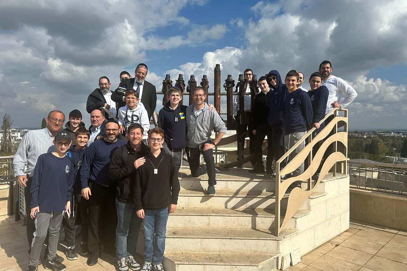 Participants of the OU Father-Son Israel Mission pose on the roof of the Hesder Yeshiva of Sderot with a menorah made of rockets fired from Gaza. Photo courtesy of Orthodox Union.