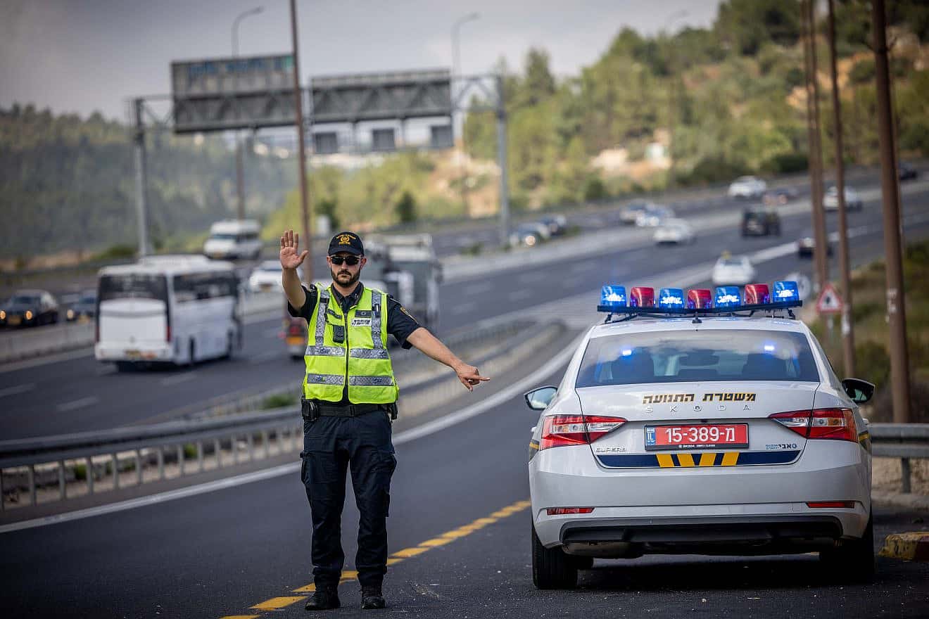 An Israel Police officers stops a car on Route 1 near Ein Hemed, July 10, 2023. Photo by Chaim Goldberg/Flash90.