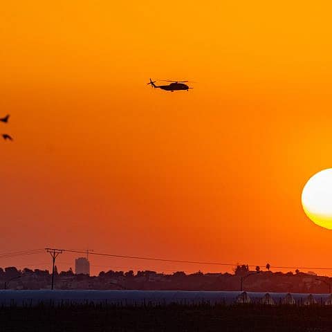 A military helicopter flies at sunset near the Israeli border with the Gaza Strip, March 11, 2024. Photo by Chaim Goldberg/Flash90.