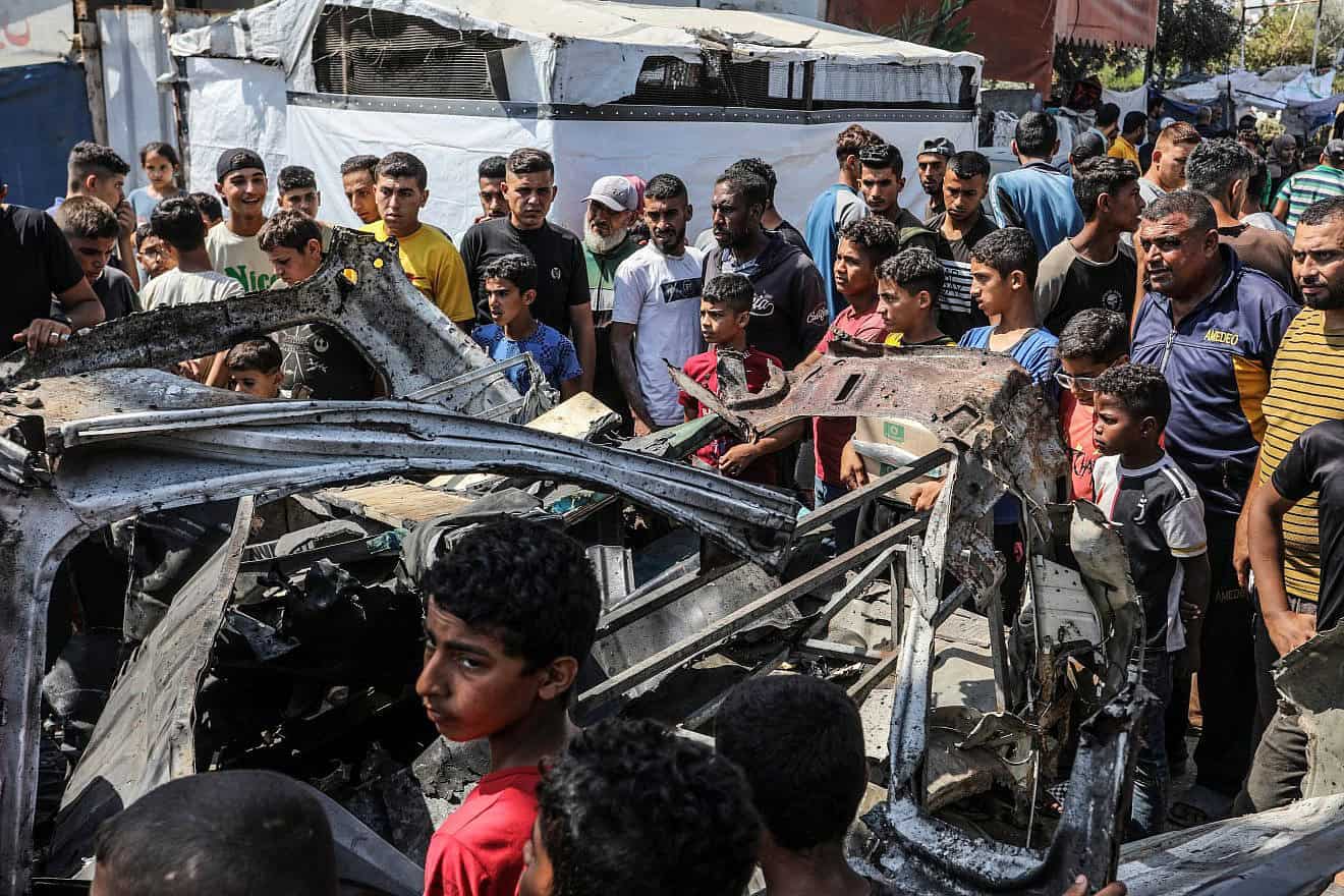 Palestinians at the site of a destroyed car hit in an Israeli airstrike, in the city of Deir al-Balah, in the central Gaza Strip, June 4, 2024. Photo by Abed Rahim Khatib/Flash90.